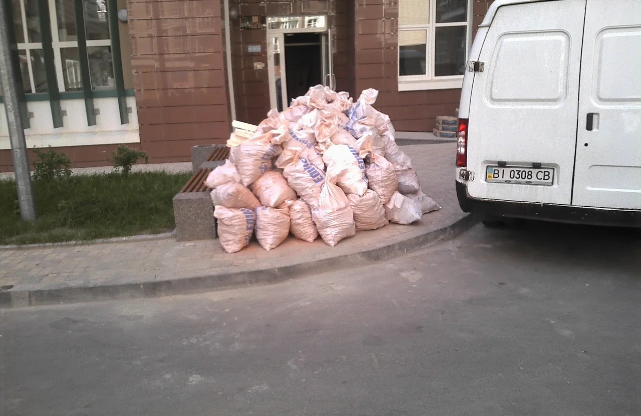 вантажники у Києві виконують збирання сміття в мішки